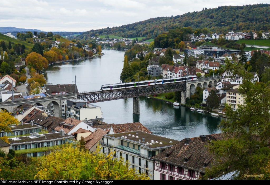 a commuter train is crossing the bridge over the river "Rhein" at Schaffhausen